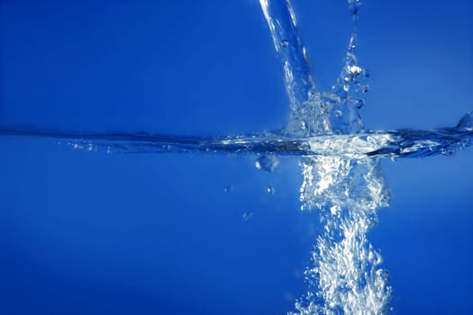 Blue water falling like splash close up macro side view