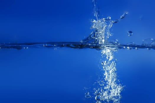 Blue water falling like splash close up macro side view