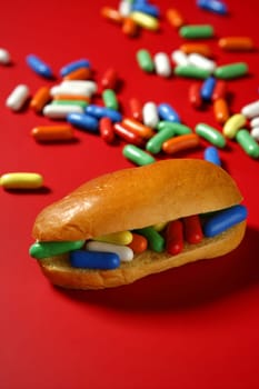 Sandwich made of colorful candy sweet, children favourites menu over red