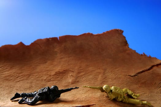 War metaphor, toy little soldiers fighting on wooden mountain
