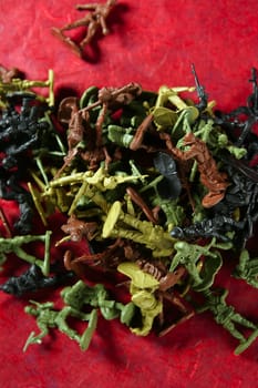 Metaphor of dead plastic toy war soldiers on a red bloody background