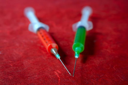 Two red and green syringe, health, addiction, medical research metaphor