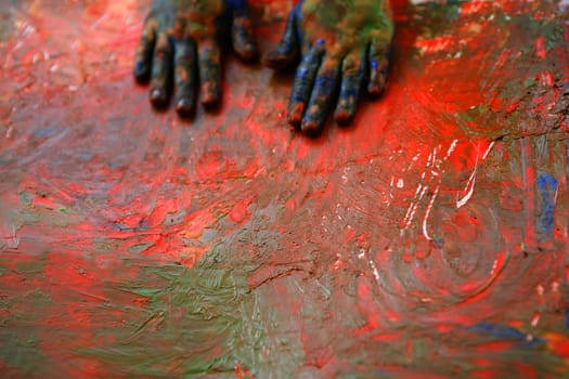 Children artist hands painting multi color with her fingers