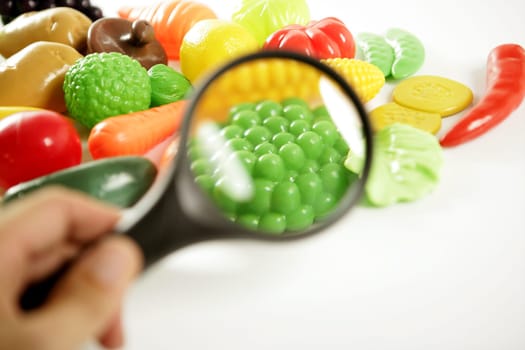 Plastic game, fake varied vegetables and fruits. Children food education toy. Looking with amplifier lens