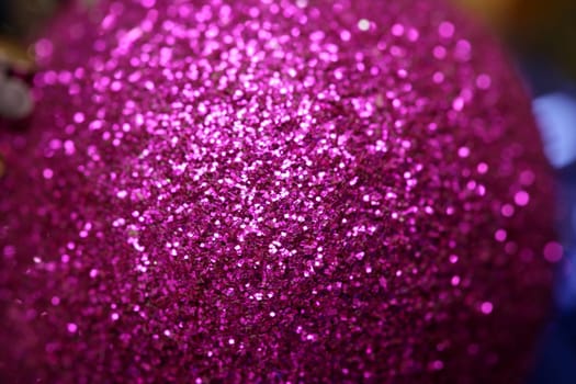 Christmas decoration, purple glitter ball, over red studio background