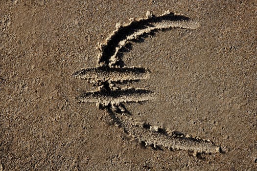 European currency Euro sign hand written on the beach sand