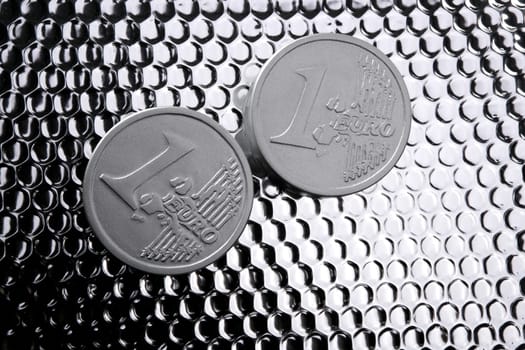 euro two silver coins over bright steel closeup