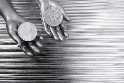 two silver euro coins in futuristic robot gray metallic hands bank metaphor