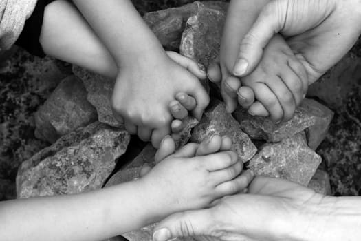 adult and chilcren holding hands around stone circle wishing desire