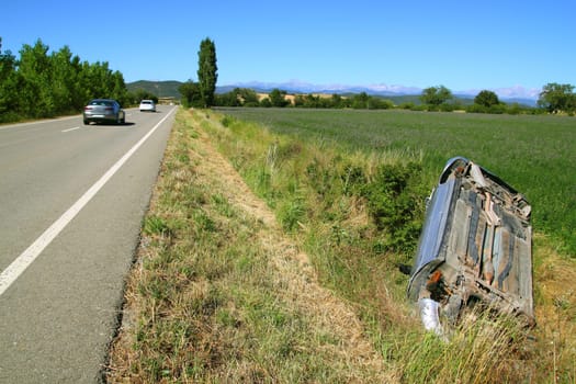 Car crash accident upside down vehicle off the road green landscape