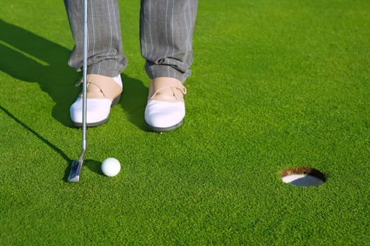 Golf green hole course man putting ball inside short putt