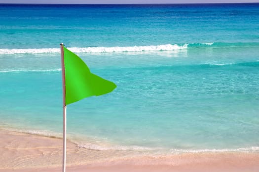 Green beach flag in  good beach weather