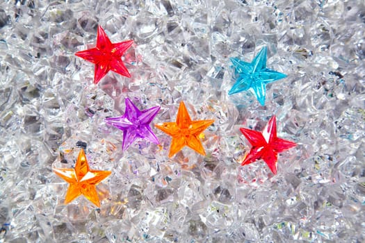 christmas colorful glass stars on cold ice background