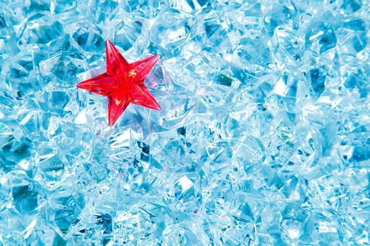 christmas red glass star on cold blue ice background