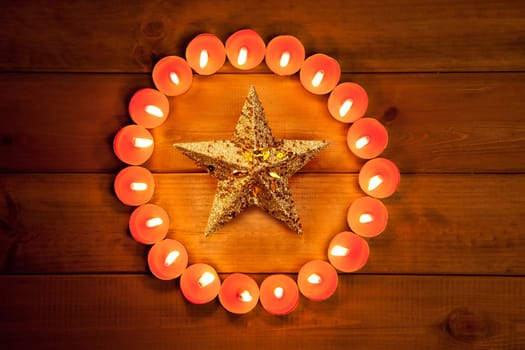 christmas candles circle over wood and golden star symbol