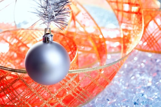 christmas silver bauble with red ribbon on ice winter background