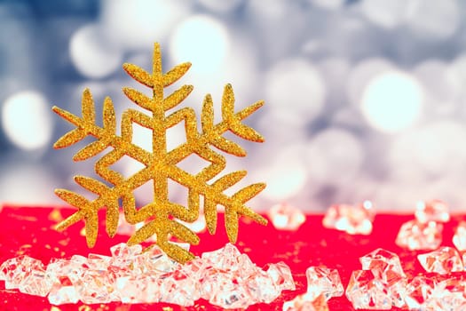 Christmas golden snowflake on ice cubes with blue lights bokeh background