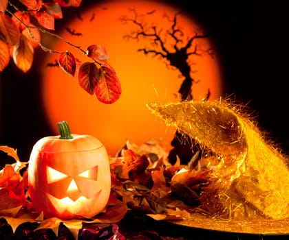 Halloween orange pumpkin lantern with autumn leaves