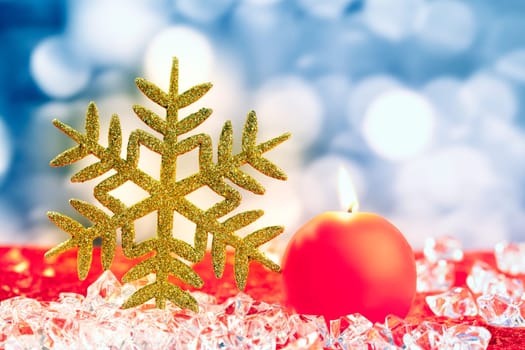 Christmas golden snowflake on ice cubes with blue lights bokeh background
