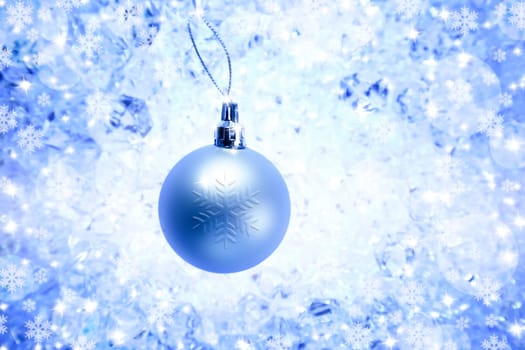 christmas silver bauble on blue winter ice background