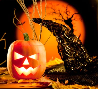 Halloween orange pumpkin lantern with autumn leaves