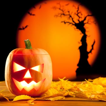 Halloween orange pumpkin lantern with autumn leaves