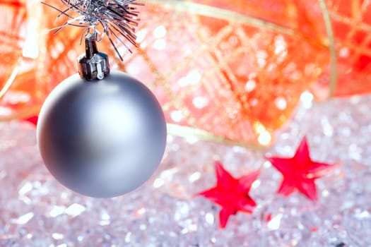 christmas silver bauble and red ribbon on ice with red star