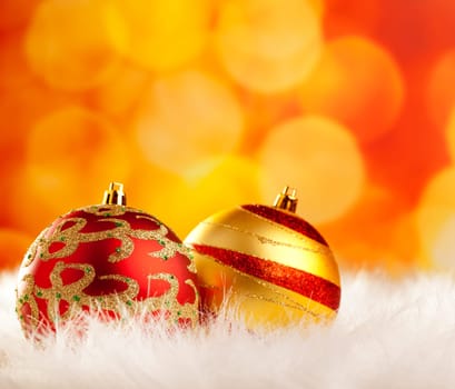 christmas baubles on white fur and colorful lights