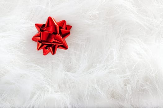 Christmas red ribbon look over white fur background