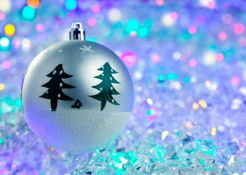 christmas silver bauble on colorful glowing ice cubes