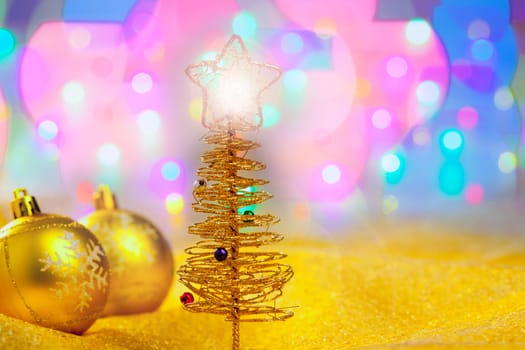 Christmas golden tree with baubles in blur lights background