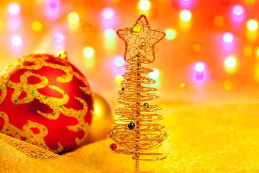 Christmas golden tree with baubles in blur lights background