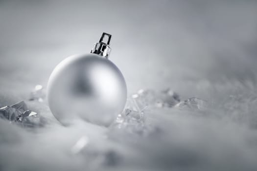 christmas silver bauble on fur snow and ice cold winter