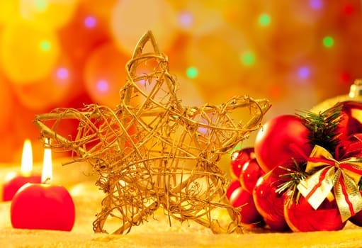 Christmas golden branch star with candles and baubles in blurred lights