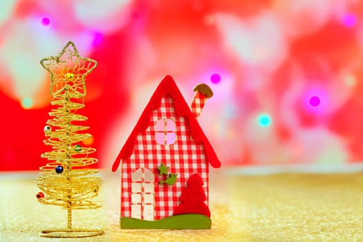 Christmas golden tree and red vichy house in blurred lights