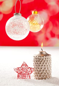 christmas silver candle and red star on snow and red with glass baubles