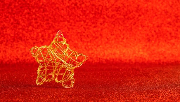 christmas gold wire star on red glitter background