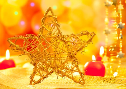 Christmas golden branch star with candles in blurred lights