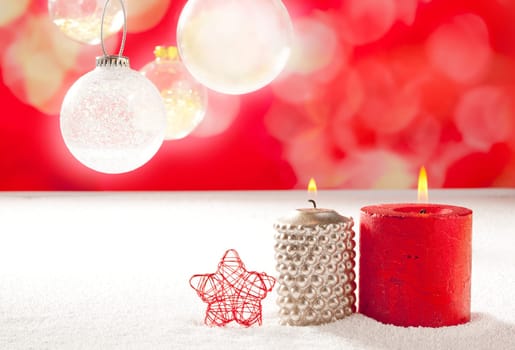 christmas silver red candles and star on snow with glass baubles