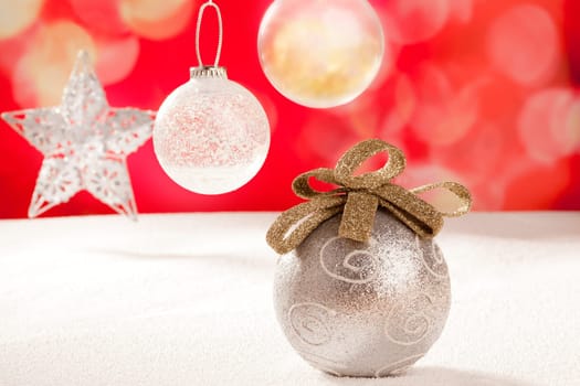 Christmas silver bauble and star on snow red background