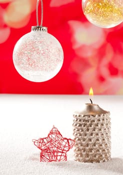 christmas silver candle and red star on snow and red with glass baubles