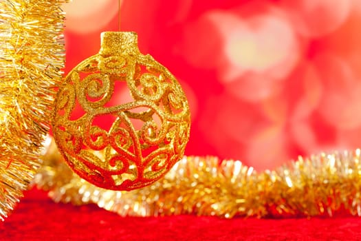 Christmas card golden bauble arabesque and tinsel on red background