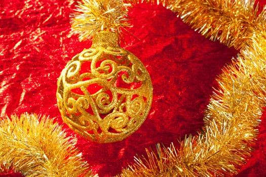 Christmas card golden bauble arabesque and tinsel on red background