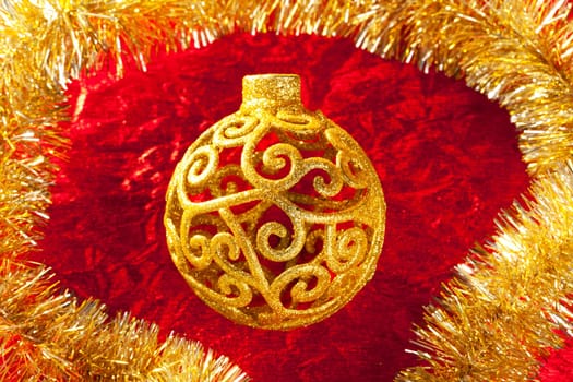 Christmas card golden bauble arabesque and tinsel on red background
