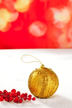 Christmas card of golden bauble berries on snow and red background