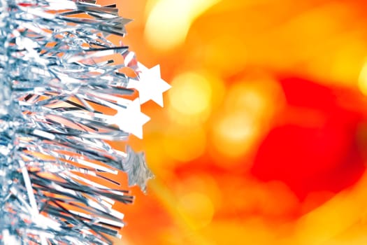 Christmas card tinsel stars silver blue on red blurred background