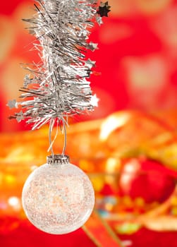 Christmas card tinsel snow crystal bauble on red blurred background