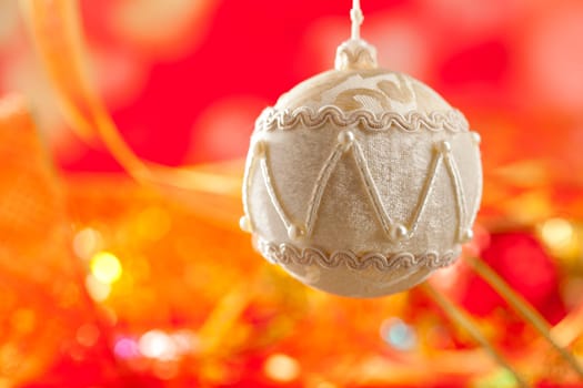 Christmas card of white velvet bauble and red blur background