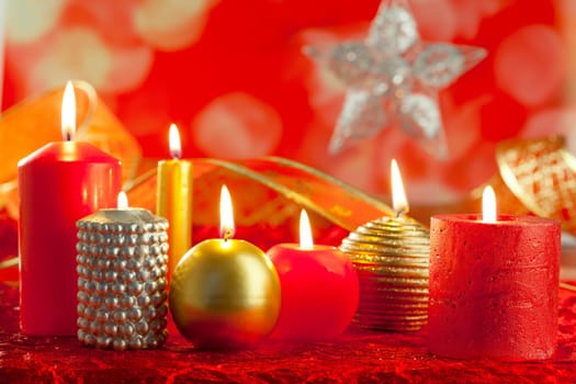 Christmas card candles red and golden in a row on blurred background