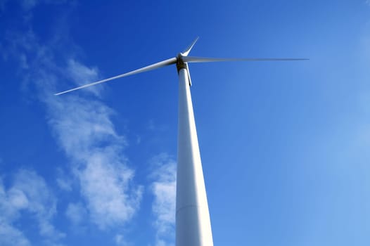 Electric wind mill viewed from the floor over blue sky, ecological windmill